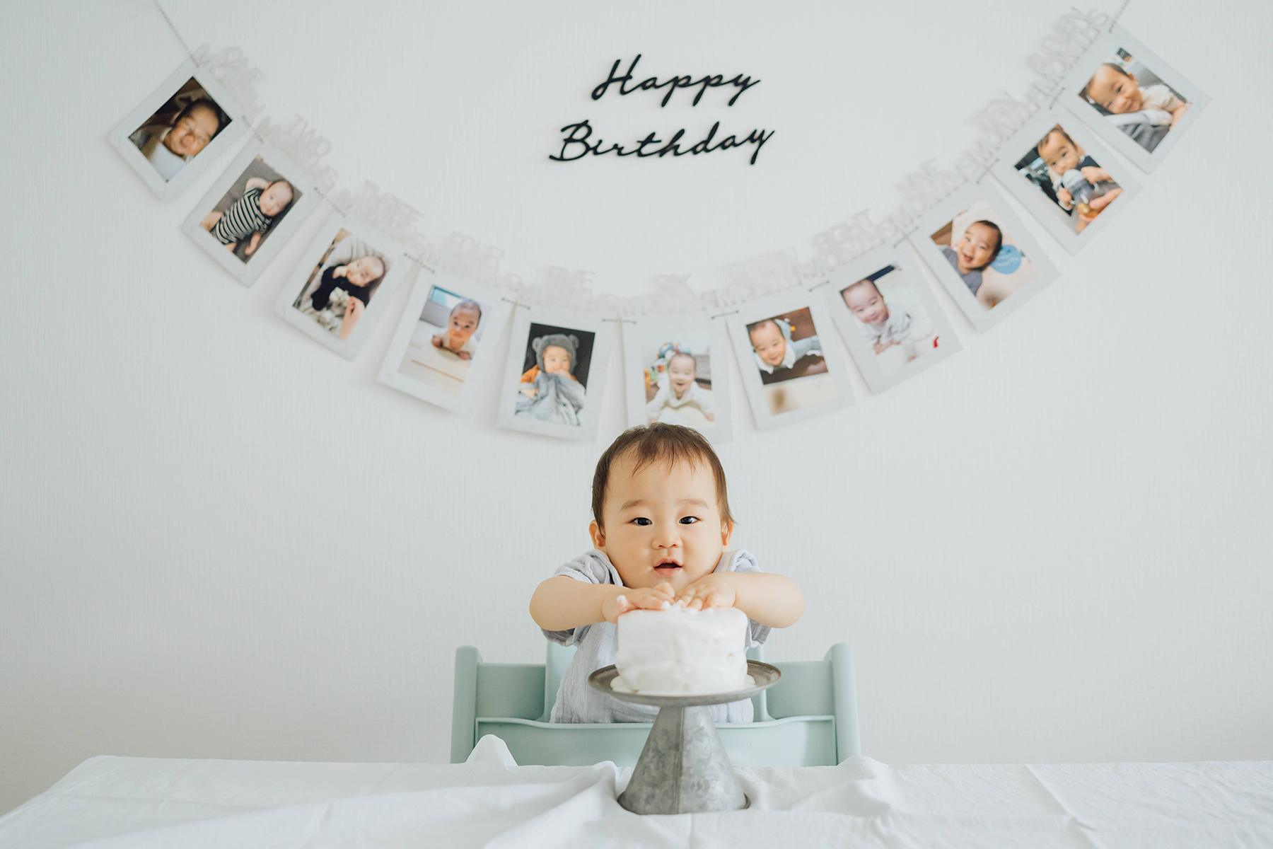 １歳の誕生日ケーキの前でポージングする子供